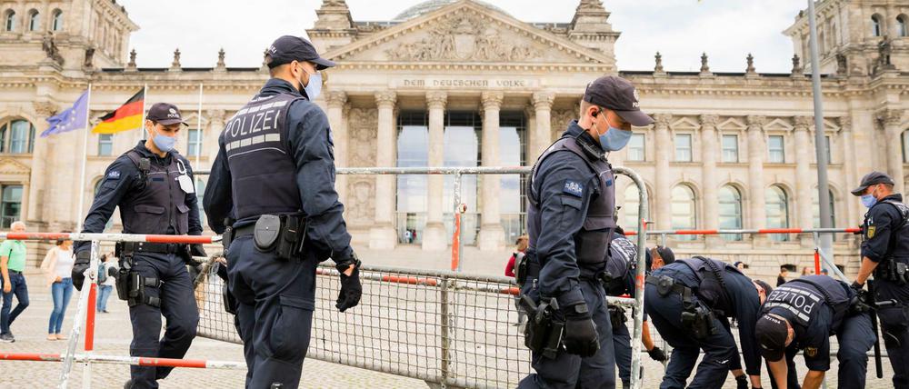 Polizisten installieren im Vorfeld der geplanten Demonstration gegen die Corona-Maßnahmen Absperrzäune vor dem Reichstagsgebäude.