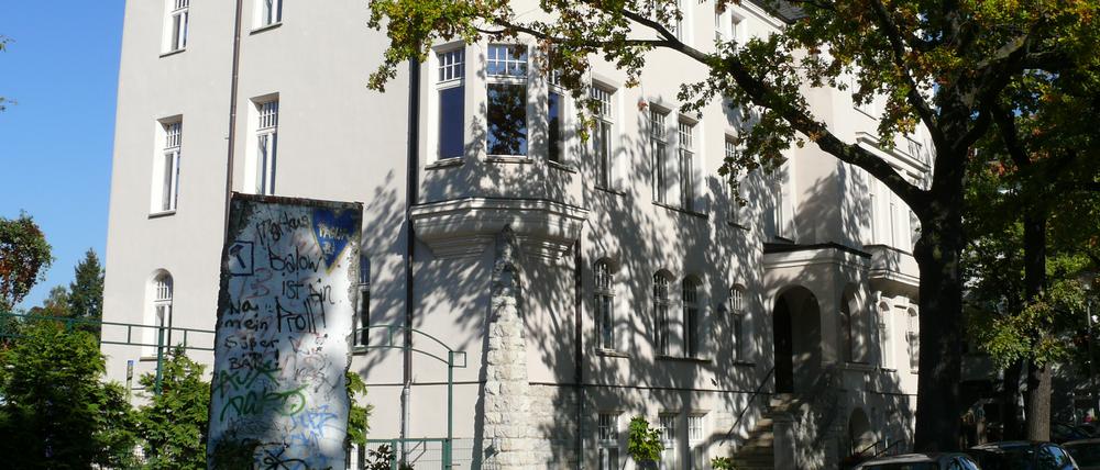 Rathaus Berlin-Johannisthal mit Mauerstück davor.