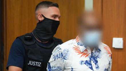 Ein Justizbeamter führt den 41-jährigen Angeklagten zum Prozessauftakt in den Gerichtssaal des Frankfurter Landgerichts.