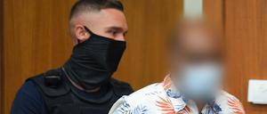 Ein Justizbeamter führt den 41-jährigen Angeklagten zum Prozessauftakt in den Gerichtssaal des Frankfurter Landgerichts.