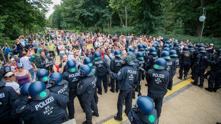 Polizisten drängen bei einem Protest gegen die Corona-Maßnahmen an der Siegessäule Menschen in den Tiergarten ab.