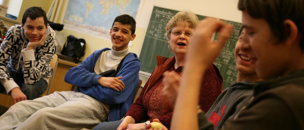 Schüler sitzen mit ihrer Lehrerin in einem Stuhlkreis und diskutieren.