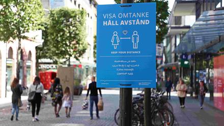 Ein Schild fordert dazu auf, Abstand einzuhalten.