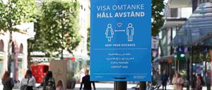 Ein Schild fordert dazu auf, Abstand einzuhalten.