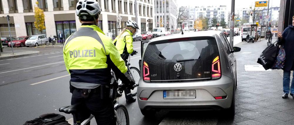 Zwei Polizisten der Fahrradstaffel der Berliner Polizei sprechen einen Falschparker an.