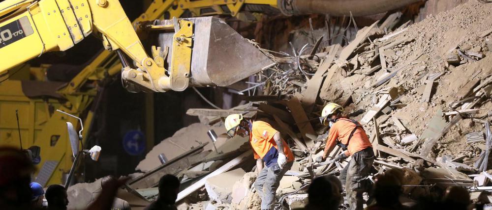 Rettungsteams auchen in den Trümmern eines eingestürzten Gebäudes in Beirut nach Überlebenden.