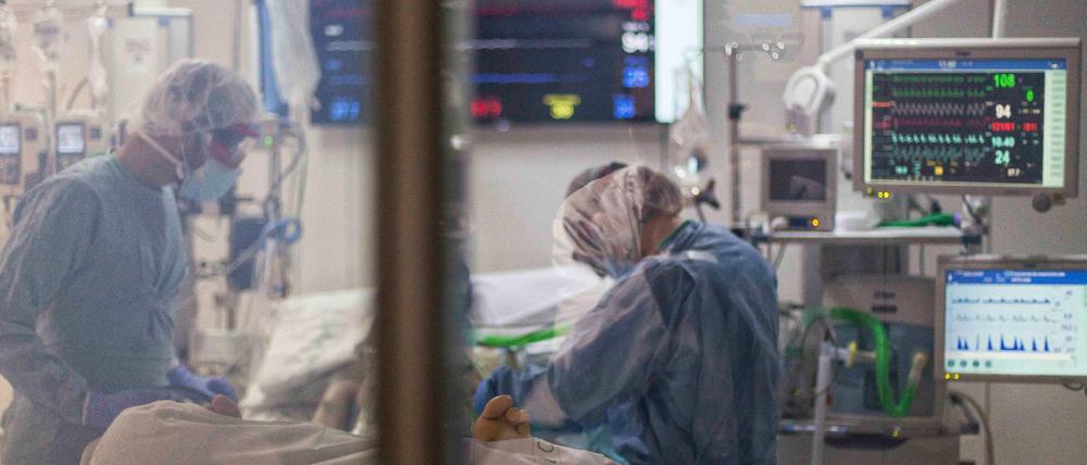 Gesundheitspersonal mit Schutanzügen behandelt einen Covid-19-Patienten auf der Intensivstation.