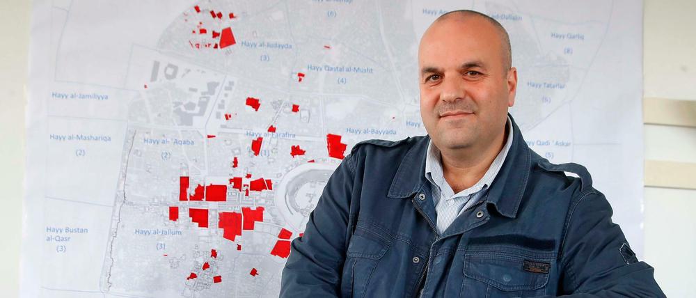 Issam Hajjar bewahrt die Erinnerung an Syrien in Bildern. Hier steht er vor einer Karte von Aleppo.