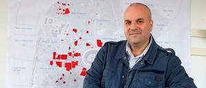 Issam Hajjar bewahrt die Erinnerung an Syrien in Bildern. Hier steht er vor einer Karte von Aleppo.