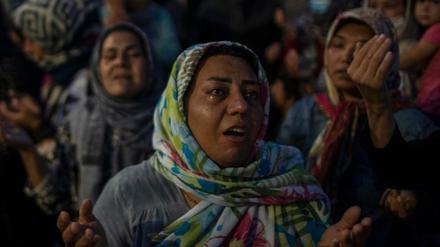 Migranten beten auf der Straße in der Nähe der Stadt Mytilini auf der Insel Lesbos.