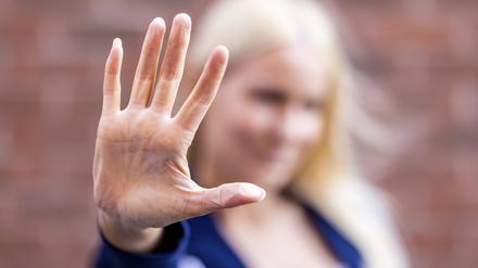 Eine blonde Frau hält ihre Handfläche vor die Kamera.