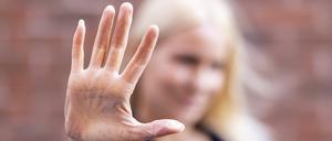 Eine blonde Frau hält ihre Handfläche vor die Kamera.