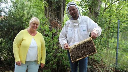 Petra Harmgardt, Regionalleiterin Berlin Ost bei Vonovia, und Imker Gunnar Schüssler mit einem Miet-Bienenvolk von Bee-Rent.