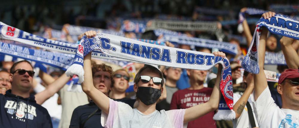Fußballfans stehen auf den Tribünen im Ostseestadion. 
