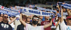 Fußballfans stehen auf den Tribünen im Ostseestadion. 