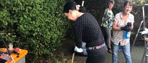 Ehrenamtliche putzen im Treptower Kunger-Kiez Garten und Hof.