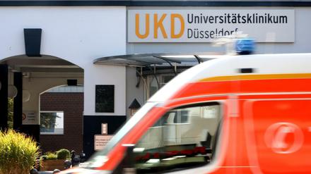 Am Haupteingang zum Universitätsklinikum Düsseldorf fährt ein Krankenwagen vorbei. 