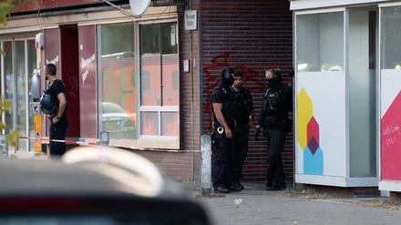 Polizeibeamte stehen in einer Einfahrt eines Gebäudekomplexes an der Goebenstraße.