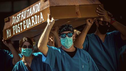 "Ich genieße die Zeit nach meinem Bereitschaftsdienst", steht symbolisch an einem Sarg geschrieben, der von Assistenzärzten bei einem Protest für bessere Arbeitsbedingungen in Barcelona getragen wird.
