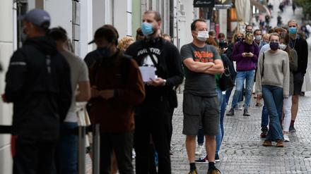 Menschen mit Mundschutz stehen in Prag an, um sich auf das Coronavirus testen zu lassen.