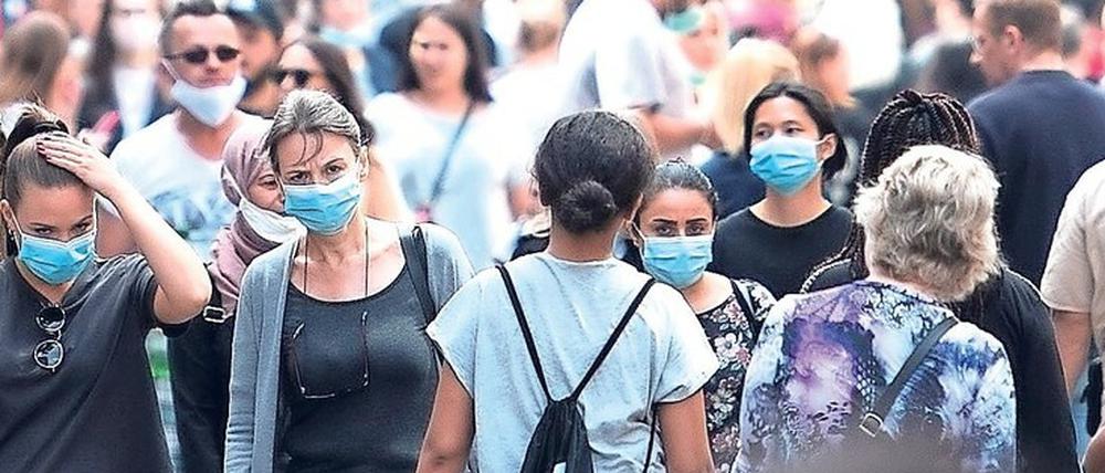In der Kölner Innenstadt tragen schon jetzt einige Besucher im Freien Masken. 