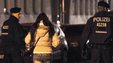 Polizisten begleiten bei einem Polizeieinsatz in Berlin eine Frau. 
