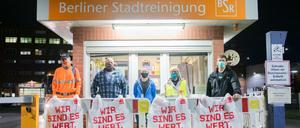 BSR-Beschäftigte und eine Verdi-Vertreterin stehen bei einem Warnstreik an der Zufahrt zum Reinigungshof Forckenbeckstraße.