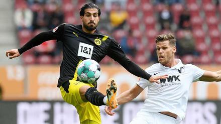 Emre Can im Duell mit Augsburgs Florian Niederlechner (r.).