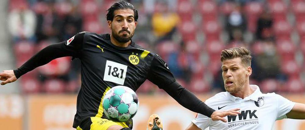 Emre Can im Duell mit Augsburgs Florian Niederlechner (r.).