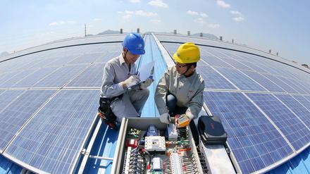 Arbeiter kontrollieren eine Solarstrom-Anlage in Dongyang in der Provinz Zhejiang.  