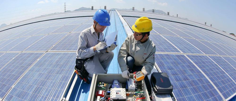 Arbeiter kontrollieren eine Solarstrom-Anlage in Dongyang in der Provinz Zhejiang.