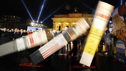 Dominosteine, die den Verlauf der Berliner Mauer symbolisieren, fallen zum 20. Jubiläum des Mauerfalls vor zehn Jahren vor dem Brandenburger Tor in Berlin.
