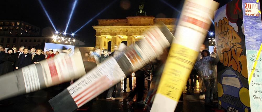 Dominosteine, die den Verlauf der Berliner Mauer symbolisieren, fallen zum 20. Jubiläum des Mauerfalls vor zehn Jahren vor dem Brandenburger Tor in Berlin.