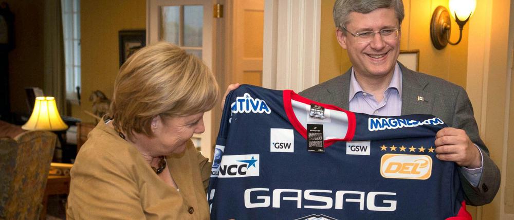 Eishockey? Haben wir auch in Deutschland: Bundeskanzlerin Angela Merkel schenkte dem damaligen kanadischen Premierminister Stephen Harper im Jahr 2012 ein Trikot der Eisbären.