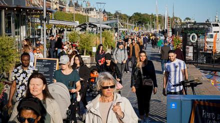 Schönes Wetter und viel los: Menschen laufen an einem sonnigen Tag durch Stockholm.