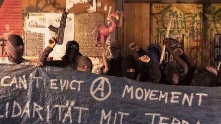 Protest mit der Attrappe einer Kalaschnikow: Vermummte posieren in der Rigaer Straße.