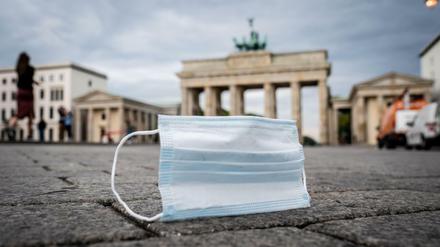 Ein Mund-Nasen-Schutz wird vom Wind über den Pariser Platz vor dem Brandenburger Tor geweht. 