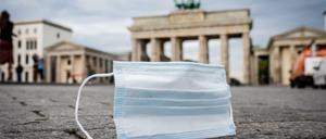 Ein Mund-Nasen-Schutz wird vom Wind über den Pariser Platz vor dem Brandenburger Tor geweht. 