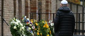 Ein Mitglied der jüdischen Gemeinde steht vor der Synagoge an Gedenkkränzen.