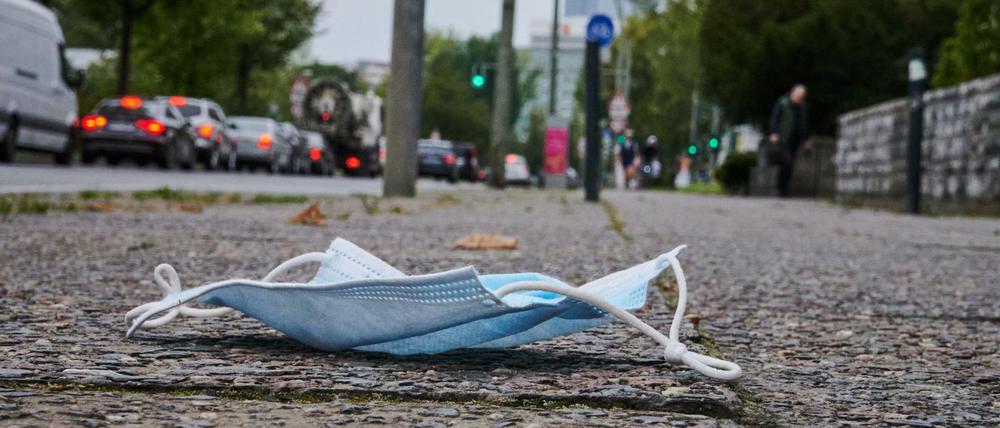Ein Mund-Nasen-Schutz liegt auf dem Gehweg in Friedrichshain.