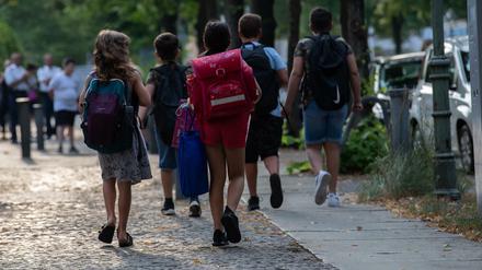 Schüler der Eichendorff-Grundschule in Charlottenburg gehen auf einem Bürgersteig. 