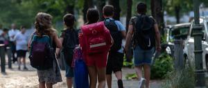 Schüler der Eichendorff-Grundschule in Charlottenburg gehen auf einem Bürgersteig. 