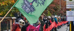 Mit rotem Band. "Hambacher Forst bleibt!" steht auf einer Fahne eine Menschenkette vor dem Verkehrsministerium.