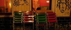 Kurz nach der Sperrstunde stehen zusammengeklappte Stühle vor einer Bar in Neukölln. 