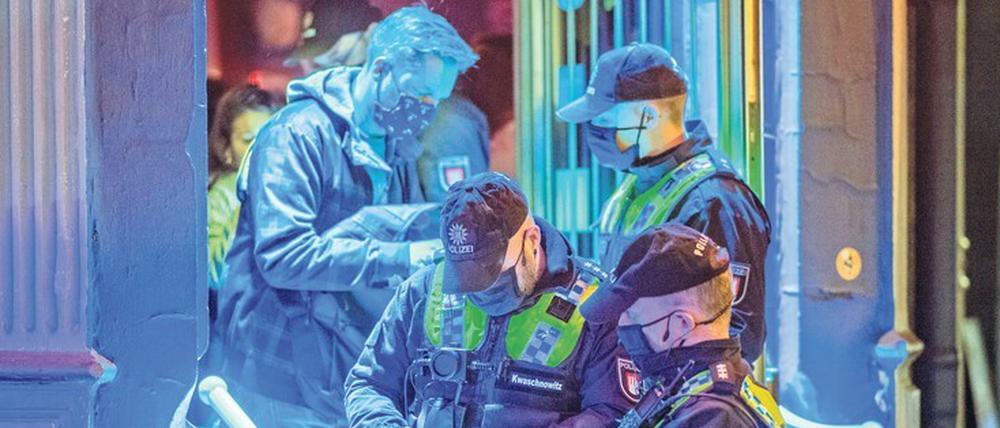 Prüfung durch die Polizei. Beamte kontrollieren in einer Hamburger Kiez-Kneipe die Einhaltung der Corona-Vorgaben.