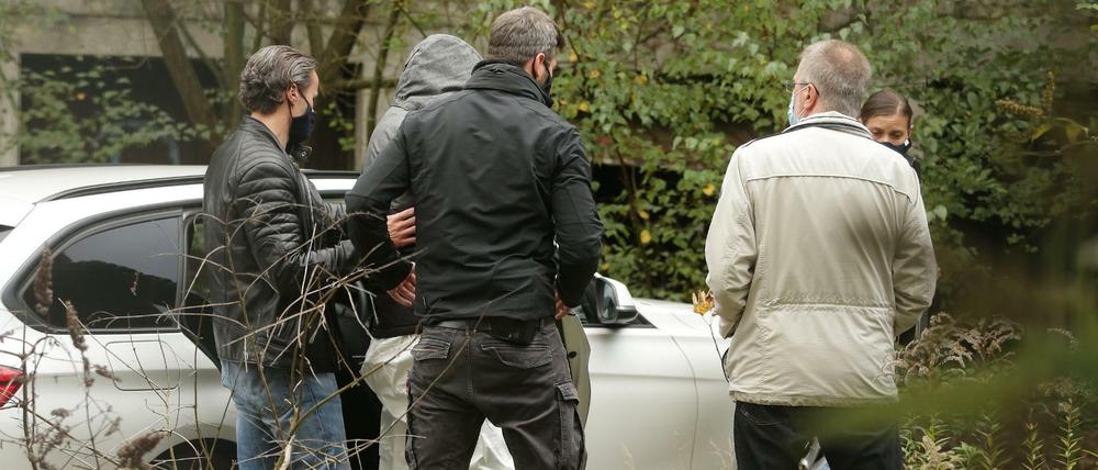 Polizisten machen eine Tatortbegehung mit dem Verdächtigen.