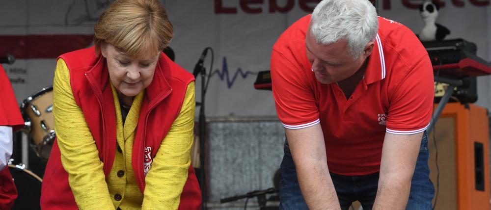 In Übung bleiben. Bundeskanzlerin Angela Merkel 2017 mit einer Reanimationspuppe auf einer Bühne in Greifswald (Mecklenburg-Vorpommern). Klaus Hahnenkamp von der Universitätsmedizin der Ernst-Moritz-Arndt-Universität Greifswald zeigt ihr die Herzdruckmassage. Bei einer Aktion haben 500 Greifswalder zeitgleich an Reanimationspuppen die Herzdruckmassage geübt.