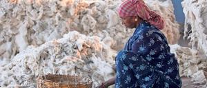 Produktion zurückverfolgen. Eine Frau sortiert Baumwolle im indischen Kolkata. 