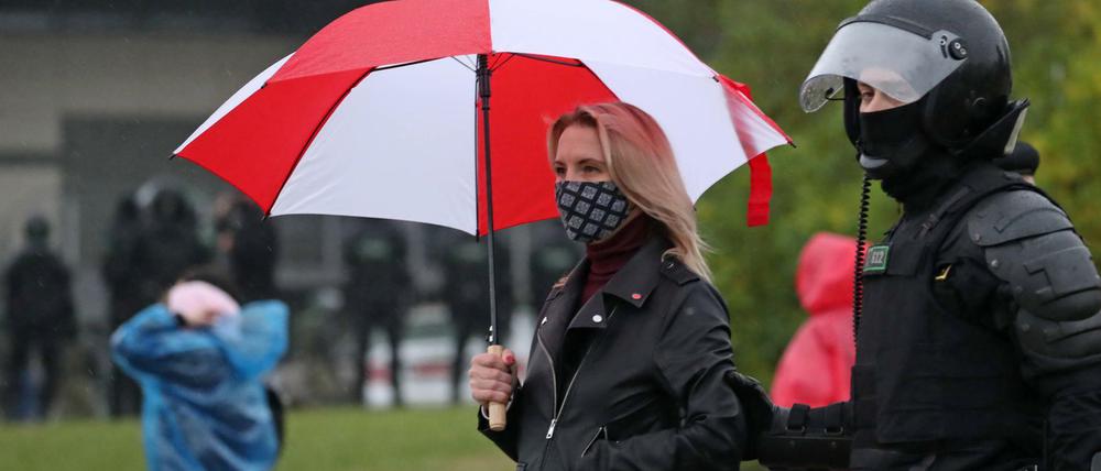 Ein Polizist führt eine Demonstrantin in Minsk ab.