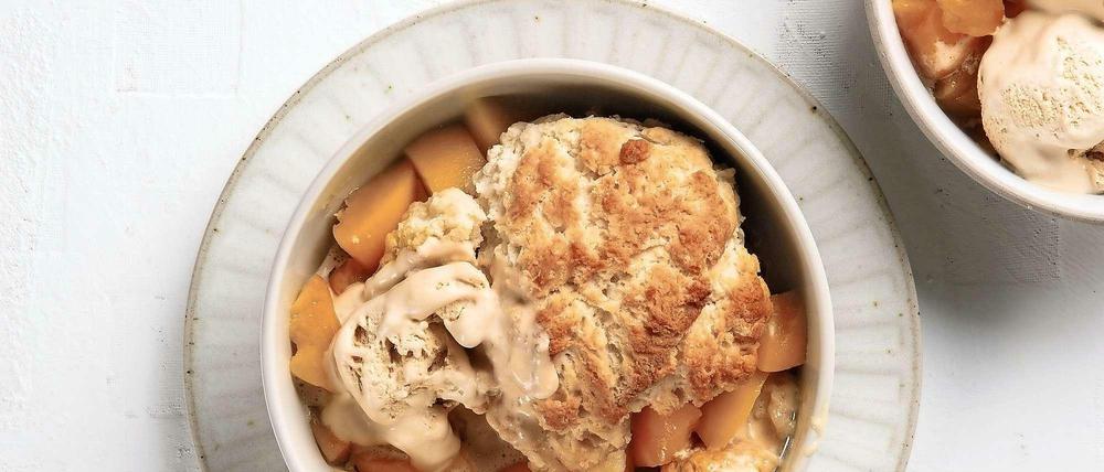 Schmeckt ofenwarm mit einer Kugel Vanilleeis erst perfekt: der Pfirsich-Cobbler - mehr Auflauf als Kuchen, aber auch schon knusprig.